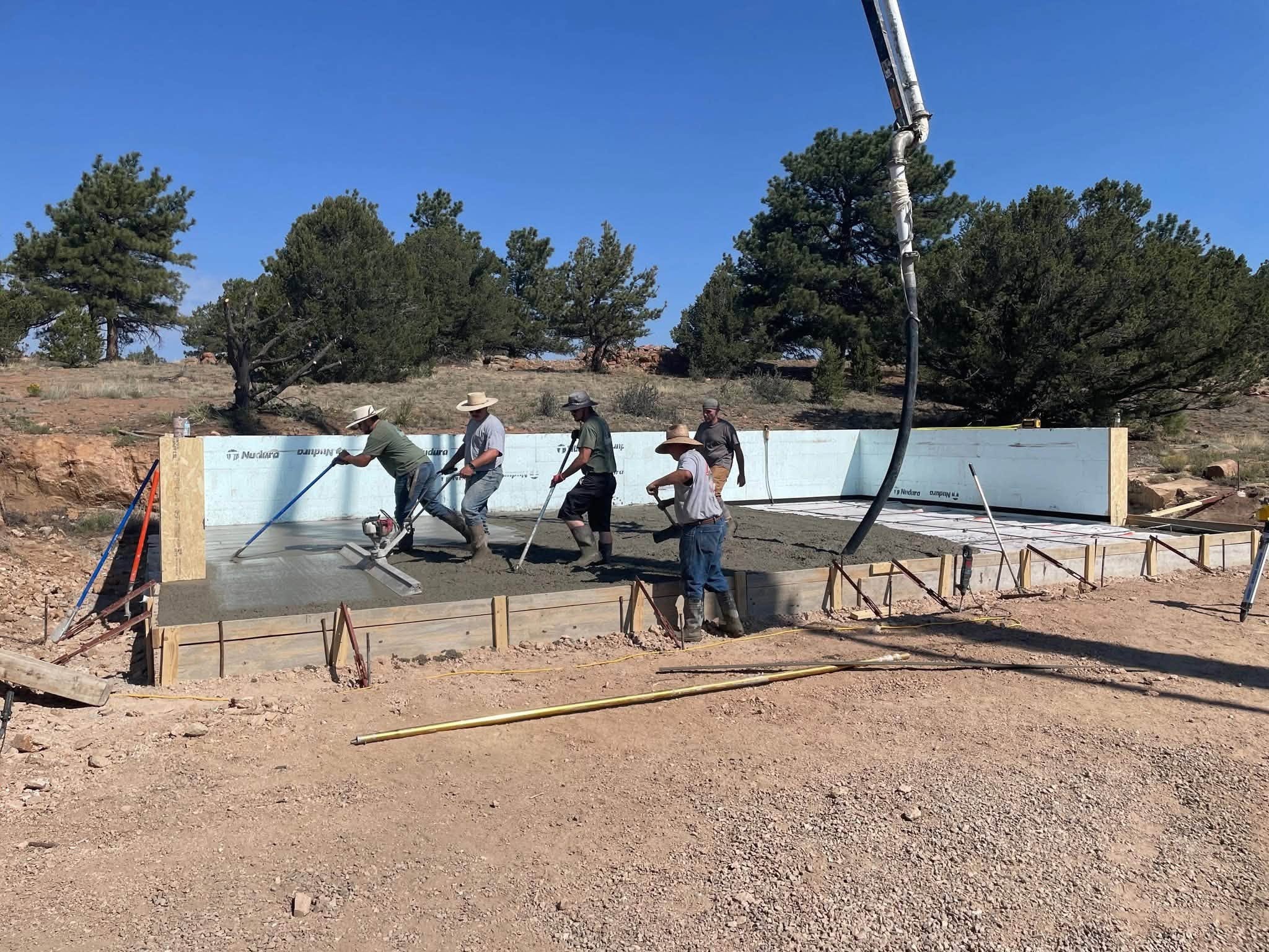 Crew finishing a concrete slab pour for the Simpson garage addition