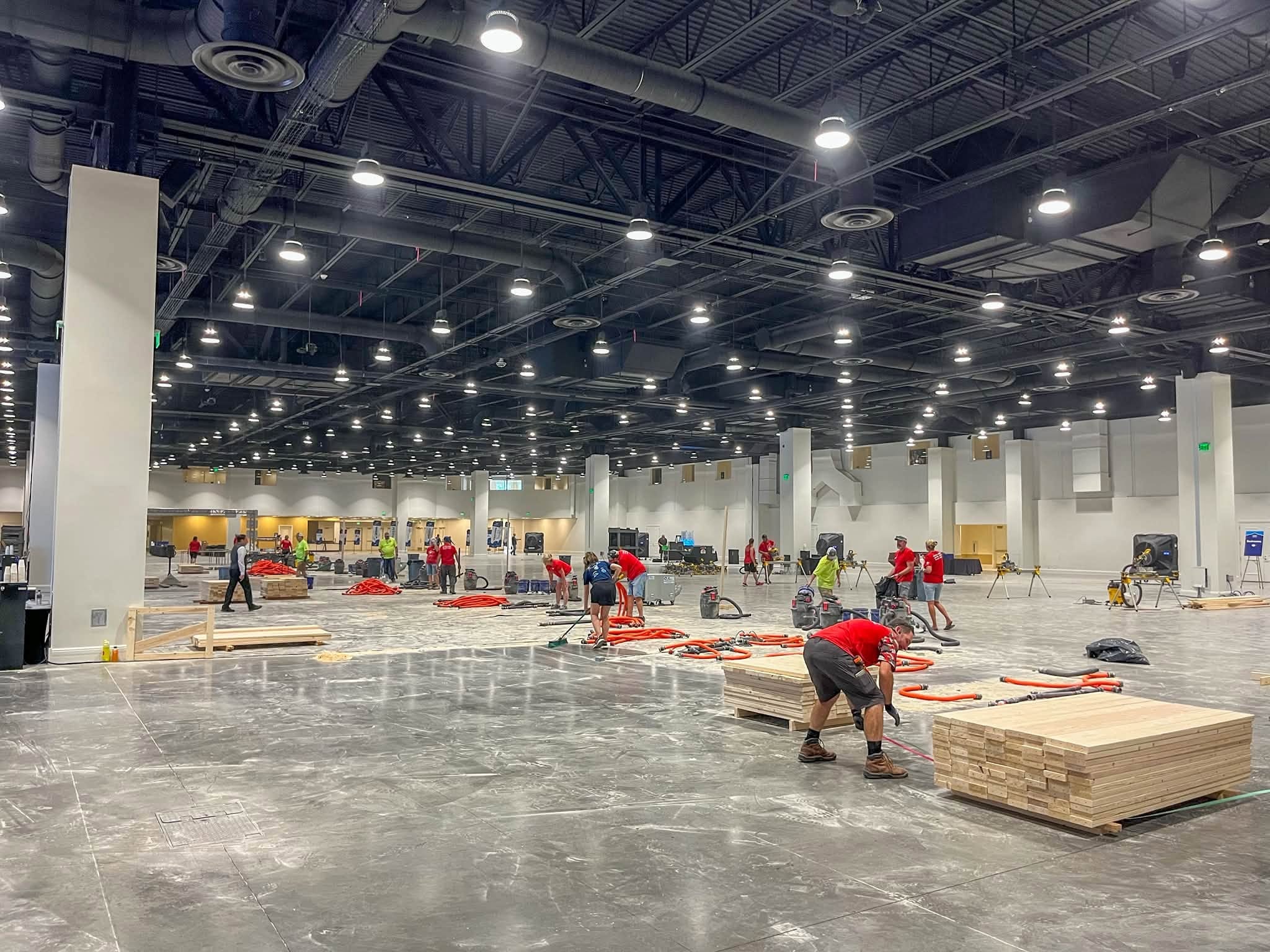 Volunteers building beds for Sleep in Heavenly Peace nonprofit at a large community event